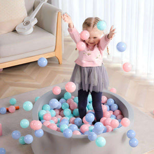 Toddler playing joyfully in BabiePlay Colourful Odyssey Ball Pit Balls in pastel pink, blue, and green colors