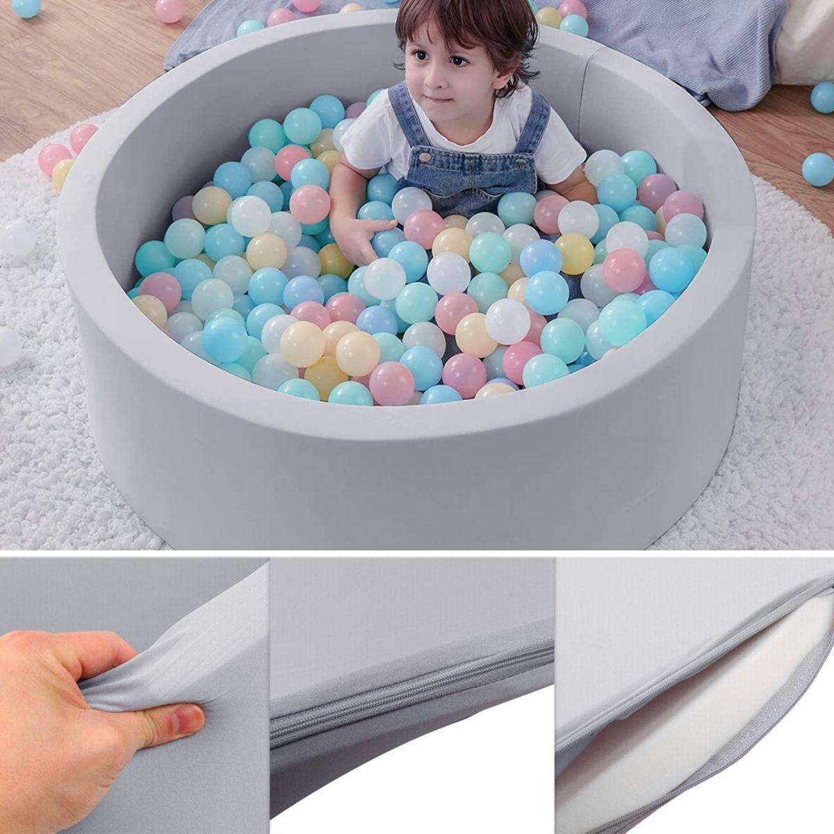 Child playing in BabiePlay Ultimate Foam Ball Pit with pastel-colored balls and removable cover.