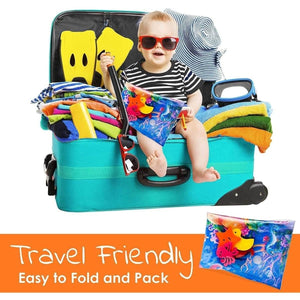 Baby with sunglasses sitting in a packed suitcase holding BabiesMart Tummy Time Water Play Mat, travel-friendly and easy to fold and pack.
