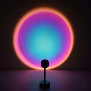 Glowly Sunset Lamp projecting colorful circular light with gradient hues on wall in dark room