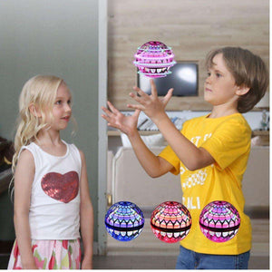 Kids playing with Kidst Flying Drone boomerang 360 rotating UFO toy with colorful LED lights indoors