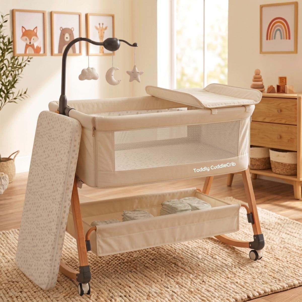 Baby Bassinet & Bedside Co-Sleeper in beige linen-cotton blend with wood-grain steel frame, mesh sides, storage basket, and hanging mobile