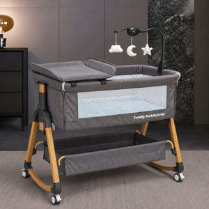 Baby Bassinet & Bedside Co-Sleeper in dark grey fabric with wooden-tone steel frame, mesh sides, storage basket and hanging mobile